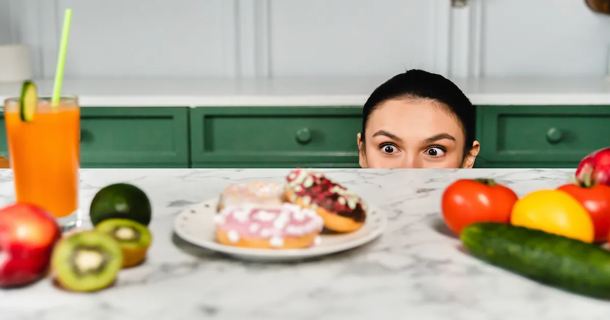 Dépendance au sucre : jeune femme tiraillée entre des aliments sains et ultra-transformés